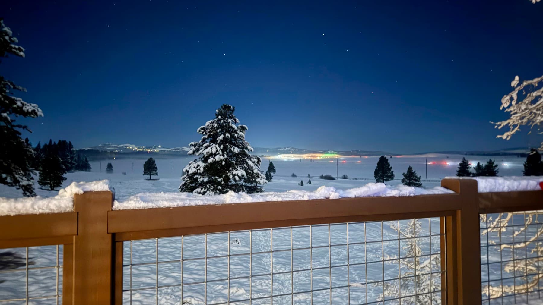 Snow-covered Northstar deck overlooking a moonlit mountain landscape
